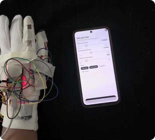 The wired glove beside a phone running the Tapp app in a dark room
